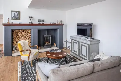 a living room with a couch and a fireplace at One The Old School, Leiston in Leiston