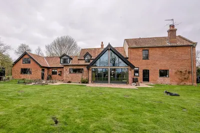 a large brick house with a large yard at Red House Loft, East Green in Saxmundham