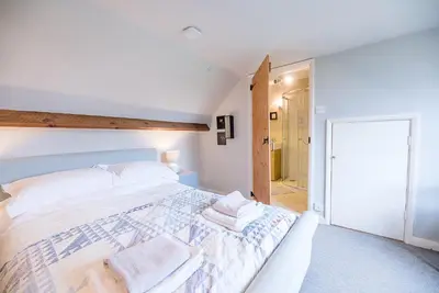 a bedroom with a large bed with towels on it at Red House Loft, East Green in Saxmundham