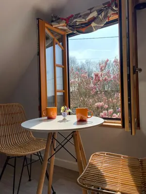 a table and two chairs in front of a window at Foxgloves self catering in Westleton