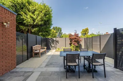 a patio with a blue table and chairs at The Fellows House Mews in Cambridge
