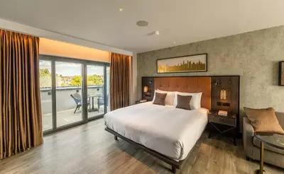 a bedroom with a large bed and a balcony at The Fellows House Mews in Cambridge