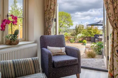 a blue chair sitting in a room with a window at Immaculate luxury retreat in pretty village with great pubs - Box Valley Cottage in Stoke by Nayland