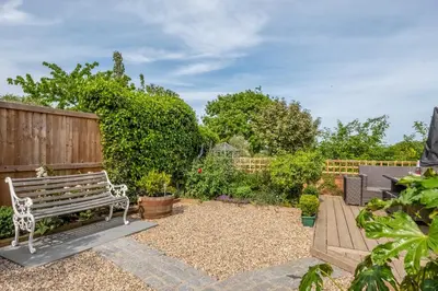 a bench sitting in the middle of a garden at Immaculate luxury retreat in pretty village with great pubs - Box Valley Cottage in Stoke by Nayland