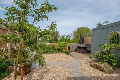 a garden with a patio and a barbecue grill at Immaculate luxury retreat in pretty village with great pubs - Box Valley Cottage in Stoke by Nayland