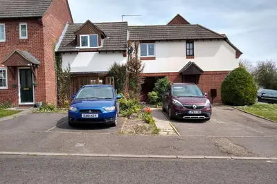 two cars parked in a parking lot in front of a house at Walking distance to hospital and town with free off-road parking in Bury Saint Edmunds