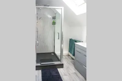 a shower with a glass door in a bathroom at Walking distance to hospital and town with free off-road parking in Bury Saint Edmunds