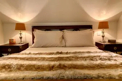 a bedroom with a large bed with two night stands at The Cartlodge in Wickham Bishops