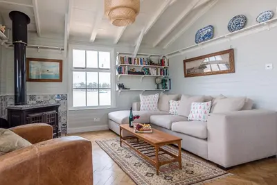 a living room with a couch and a table at The Boathouse in Felixstowe Ferry - Stunning Waterfront Property in Felixstowe