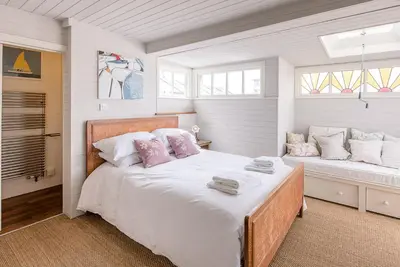 a bedroom with a bed with pink and white pillows at The Boathouse in Felixstowe Ferry - Stunning Waterfront Property in Felixstowe