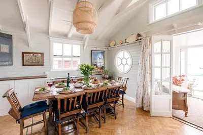 a large dining room with a table and chairs at The Boathouse in Felixstowe Ferry - Stunning Waterfront Property in Felixstowe