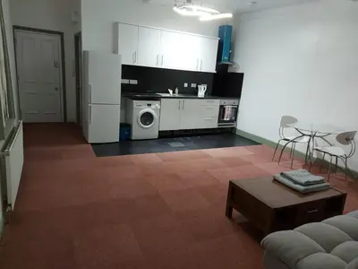 a kitchen with a refrigerator and a table in a room at Queen Suite in Ipswich