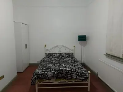 a bedroom with a bed in a white room at Queen Suite in Ipswich