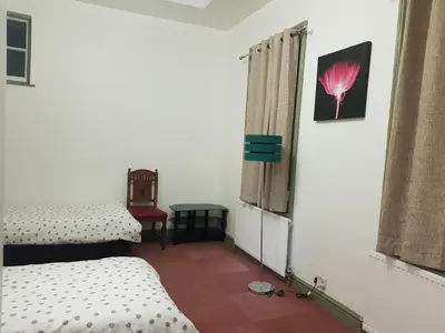 a room with two beds and a window at Costa Suite in Ipswich
