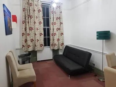 a waiting room with a couch and a window at Costa Suite in Ipswich