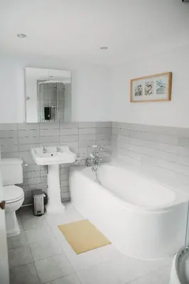 a bathroom with a tub and a sink and a toilet at Hazel's in Leiston