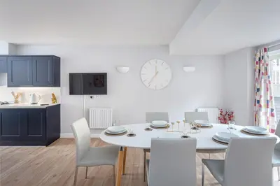 a kitchen and dining room with a white table and chairs at 3 Bedroom Jesus Green Townhouse with Parking in Cambridge