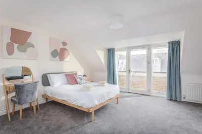 a bedroom with a bed and a desk and window at 3 Bedroom Jesus Green Townhouse with Parking in Cambridge