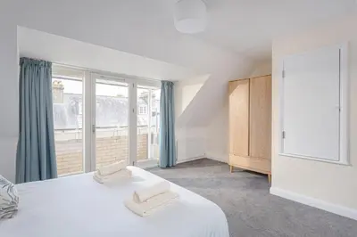 a bedroom with a bed and a large window at 3 Bedroom Jesus Green Townhouse with Parking in Cambridge