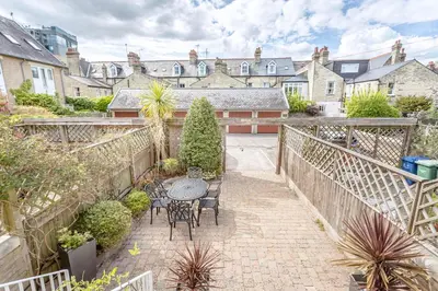 a patio with a table and chairs in a courtyard at 3 Bedroom Jesus Green Townhouse with Parking in Cambridge