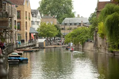 a river with boats in a city with buildings at 3 Bedroom Jesus Green Townhouse with Parking in Cambridge