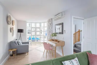 a living room with a green couch and a table at 3 Bedroom Jesus Green Townhouse with Parking in Cambridge
