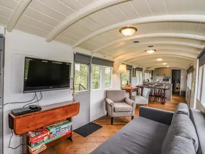 a living room with a couch and a flat screen tv at The Carriage at High Barn Heritage in Halstead