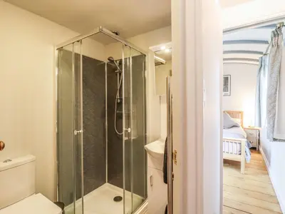 a bathroom with a shower with a glass shower stall at The Carriage at High Barn Heritage in Halstead