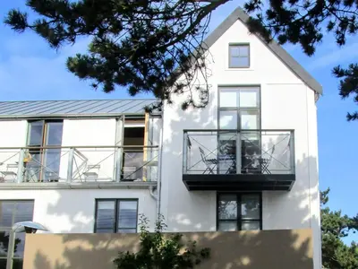 a white house with a balcony on it at Regatta - A lakeview apartment in Thorpeness - Aldeburgh Coastal Cottages in Thorpeness