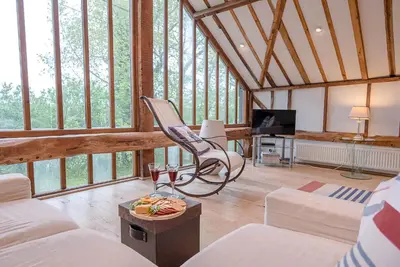 a living room with a couch and a chair at The Hayloft, Clopton in Clopton