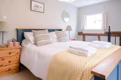 a bedroom with a bed with towels on it at Lavender Cottage, Middleton in Saxmundham