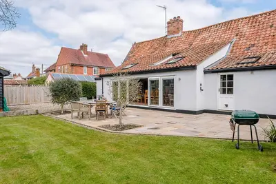 a patio with a table and chairs in a yard at Lavender Cottage, Middleton in Saxmundham