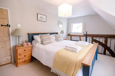 a bedroom with a bed and a table with towels on it at Lavender Cottage, Middleton in Saxmundham
