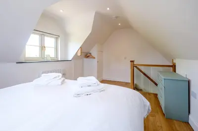 a bedroom with a white bed with a blue cabinet at Foxes Lodge in Aldringham
