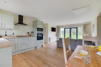 a kitchen and living room with a table and a couch at 2 Bed in Weybread oc-tclwey in Needham
