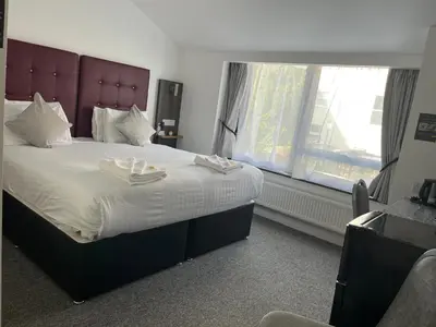 a bedroom with a large bed with two towels on it at Kings Hotel in Newmarket
