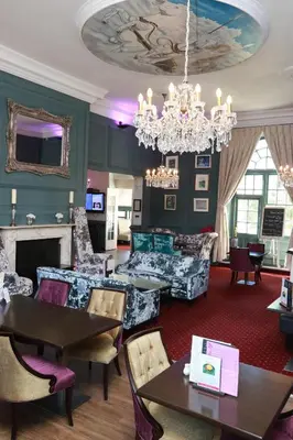 a living room with furniture and a chandelier at Kings Hotel in Newmarket