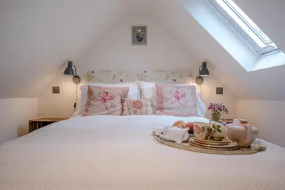 a bedroom with a bed with a tray of food on it at The Wash House, Middleton in Saxmundham