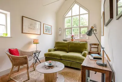 a living room with a green couch and a table at The Wash House, Middleton in Saxmundham