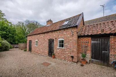 a brick building with a door and a garage at The Wash House, Middleton in Saxmundham