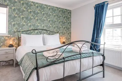 a bedroom with a bed and a green wall at The Grange, Aldeburgh in Aldeburgh