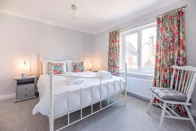 a bedroom with a bed and a window and a chair at The Grange, Aldeburgh in Aldeburgh