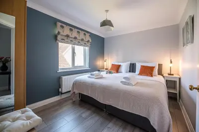 a bedroom with a large bed and a window at The Grange, Aldeburgh in Aldeburgh