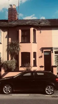 a black car parked in front of a house at Comfortable Room or Whole House - 4BR 1BATH 1TOILET at Suffolk Pink House, Newmarket in Newmarket