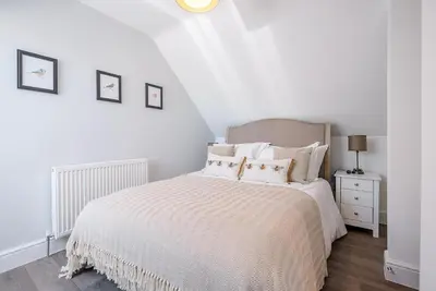 a white bedroom with a bed with white sheets and pillows at Geoff's Rest at Pond Hall Farm in Hadleigh with Private Hot Tub in Ipswich