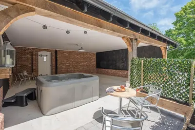 an outdoor patio with a tub and a table at Geoff's Rest at Pond Hall Farm in Hadleigh with Private Hot Tub in Ipswich