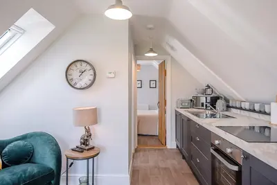a kitchen with a sink and a clock on the wall at Geoff's Rest at Pond Hall Farm in Hadleigh with Private Hot Tub in Ipswich