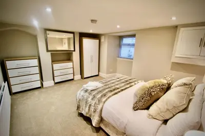 a bedroom with a bed and a dresser at Mill House Townhouse in Newmarket