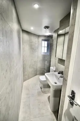 a bathroom with a white sink and a toilet at Mill House Townhouse in Newmarket