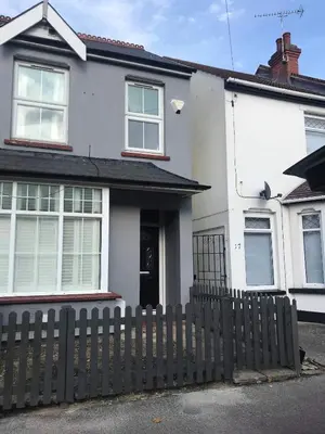 a white house with a fence in front of it at A Wave From It All in Great Clacton